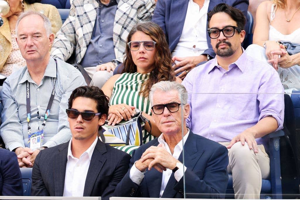 Pierce looked characteristically suave in a navy double-breasted jacket, wearing his white shirt open at the collar and completing the outfit with oversized dark-framed glasses