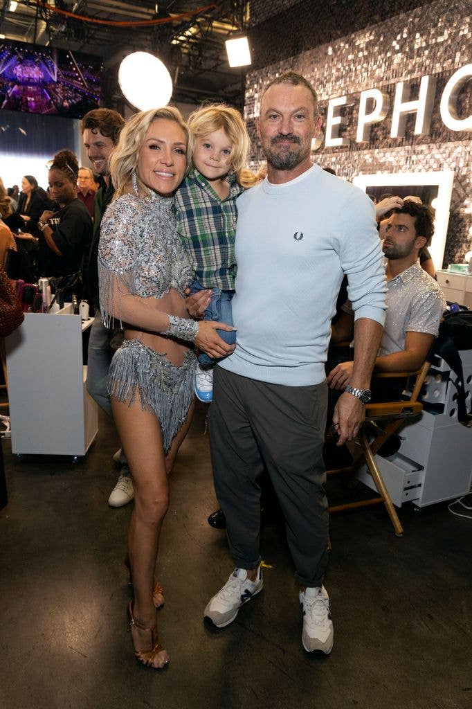 Sharna Burgess holding her son, standing next to Brian Austin Green