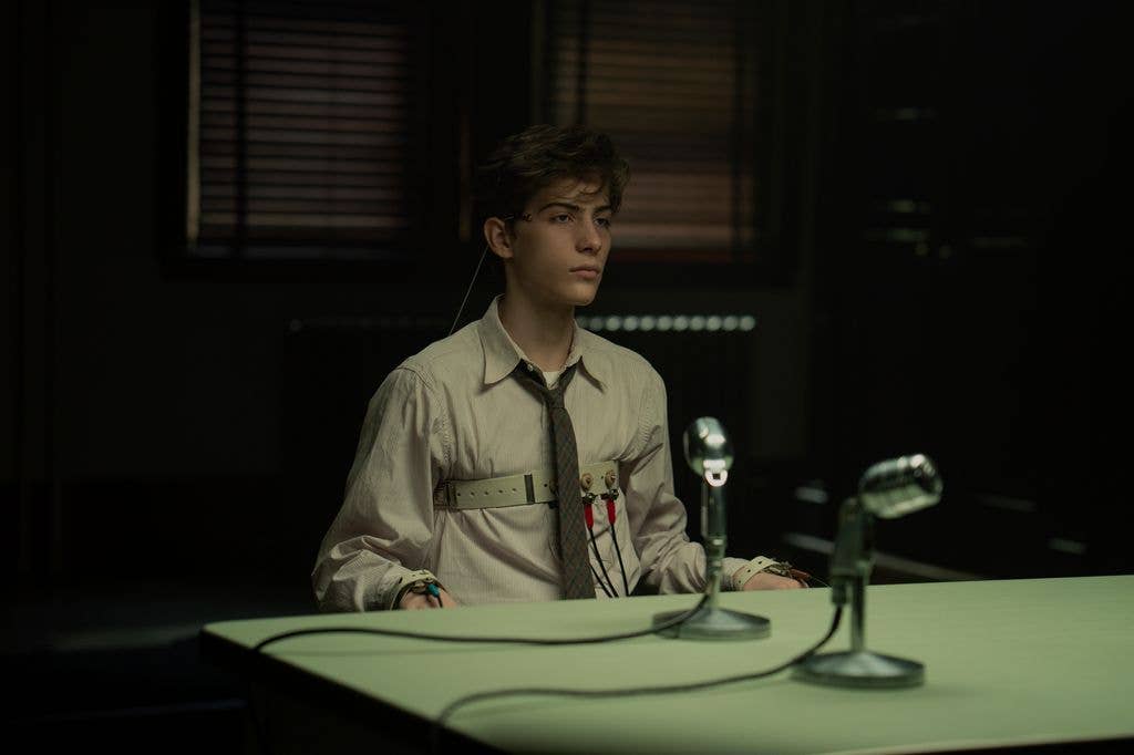 Jacob Tremblay in a white shirt and tie, seated at a table with microphones.