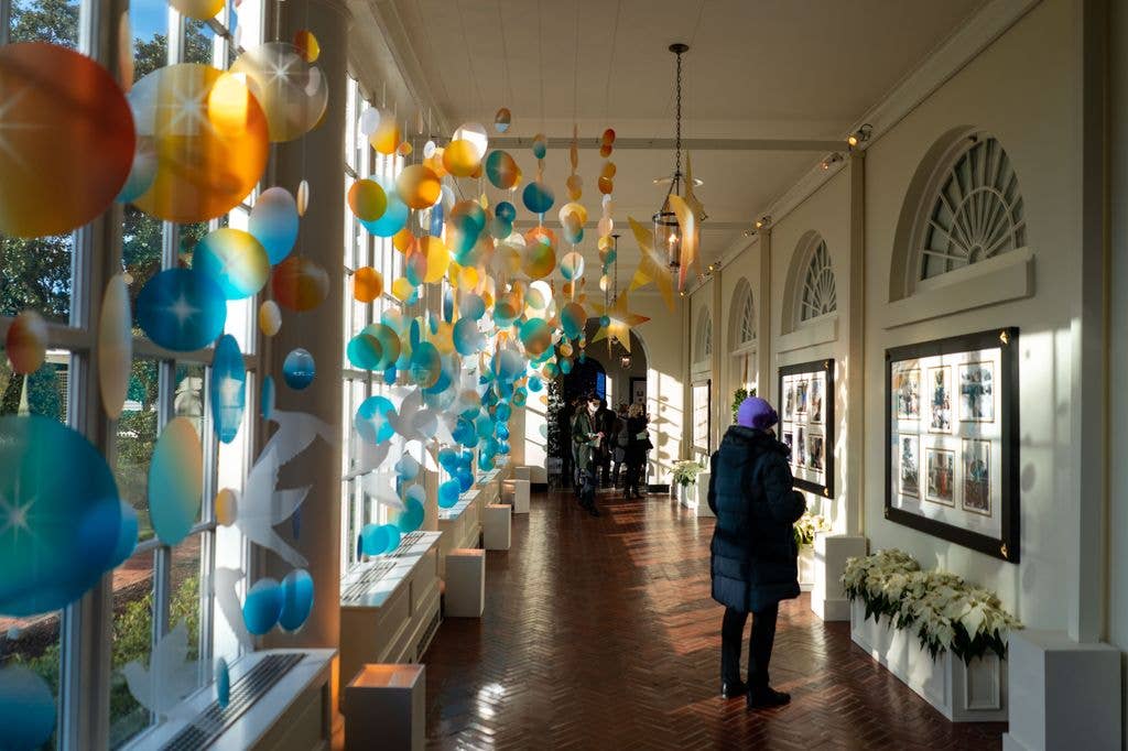 People make their way through the East Colonnade of the East Wing of the White House, viewing the themed Gifts from the Heart Holiday decorations on Thursday, Dec. 23, 2021 in Washington, DC