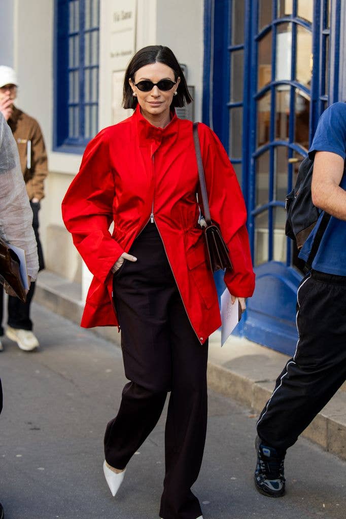 A fashion week guest wears a red jacket