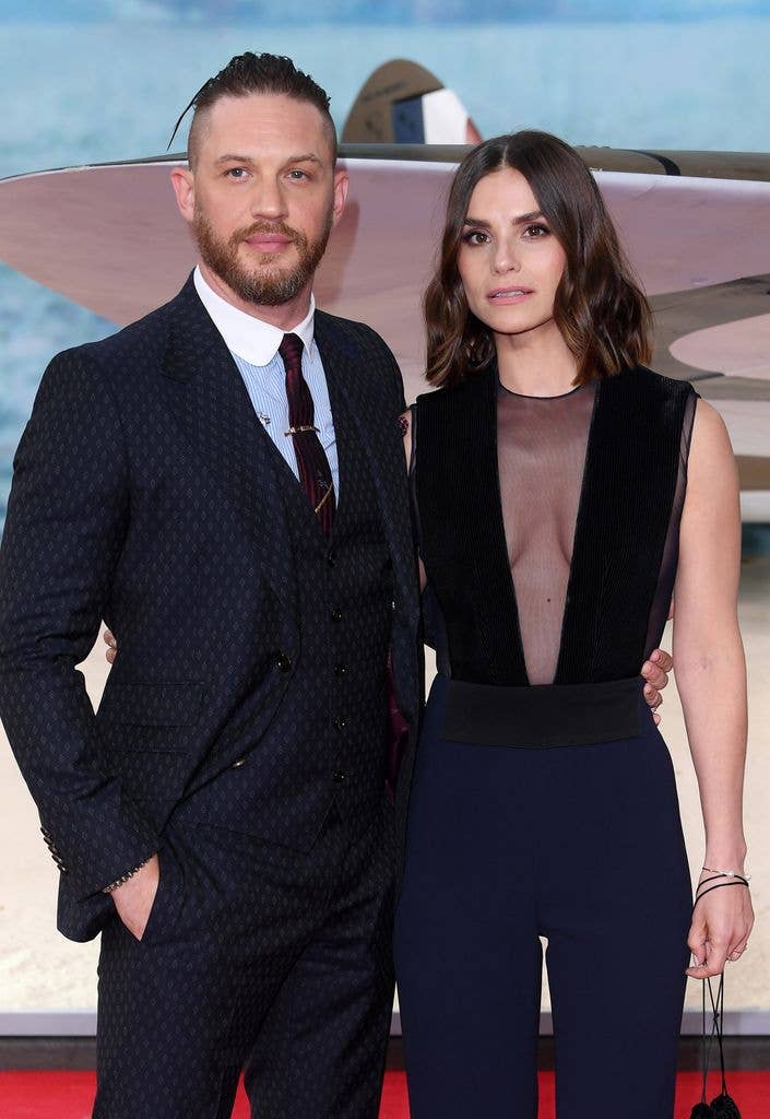 Man and women posing on red carpet