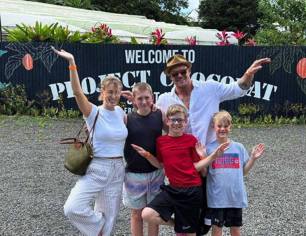 Alan and Catherine posing with three sons while on vacation