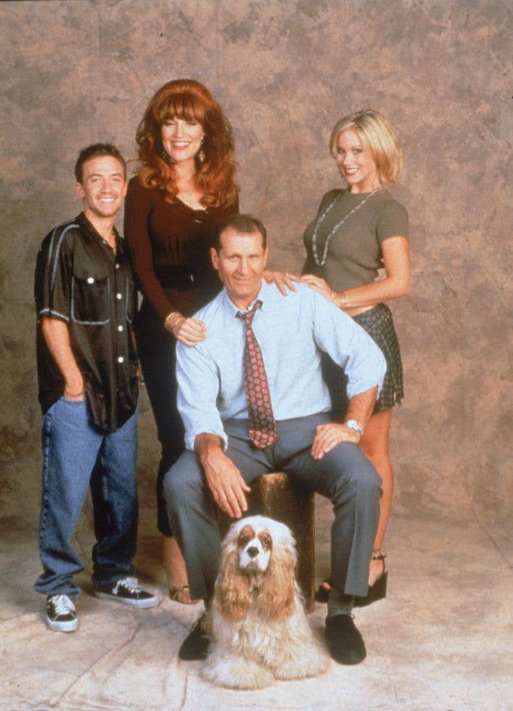 David Faustino, Katey Sagal, Christina Applegate and Ed O'Neill pose for a studio portrait with a spaniel dog, Ed O'Neill seated centre.