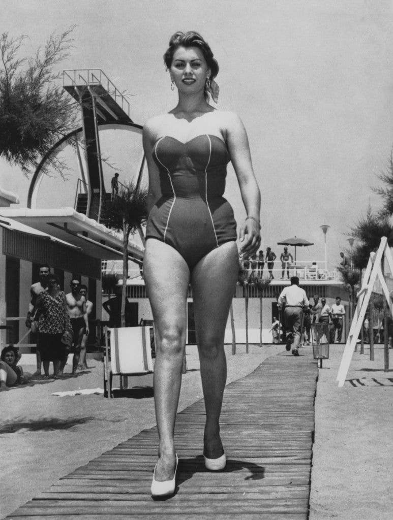 Italian actress Sophia Loren wearing a one-piece swimsuit to the beach, circa 1956.