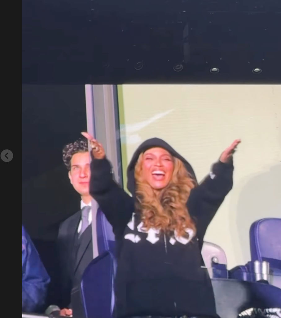 Beyonce laughing with her arms in the air